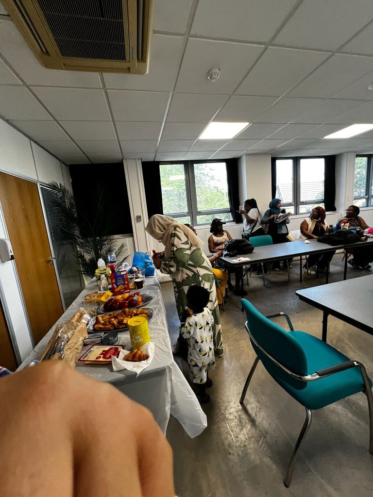 Women and children gathered around food at a Womenion community session