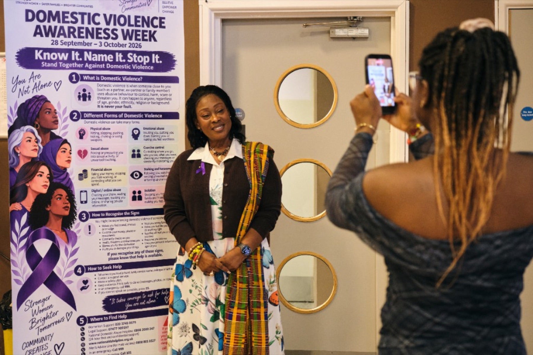 A woman beside the Womenion awareness banner at the conference, 3 October 2026